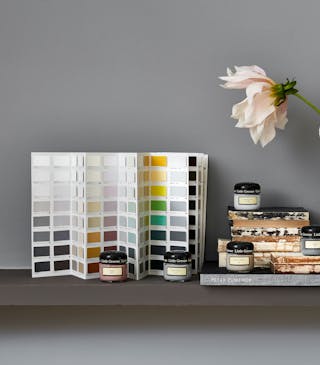 Pots d’échantillons Little Greene posés devant un nuancier